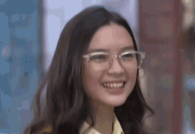 a close up of a woman wearing glasses smiling .