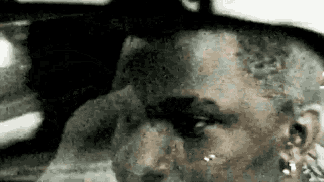 a black and white photo of a man 's face with a blurred background
