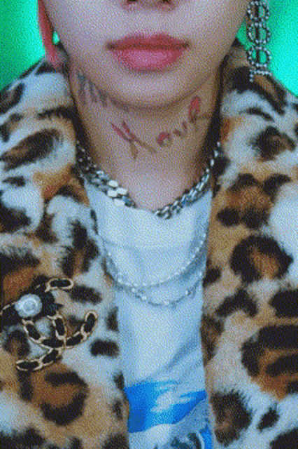 a close up of a person wearing a leopard print jacket and a pearl necklace .