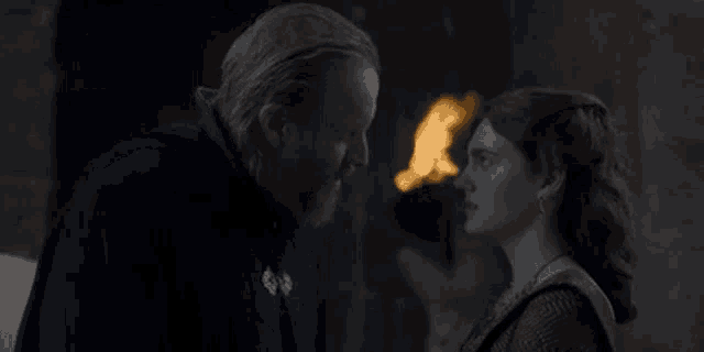 a man and a woman are kissing in a dark room .