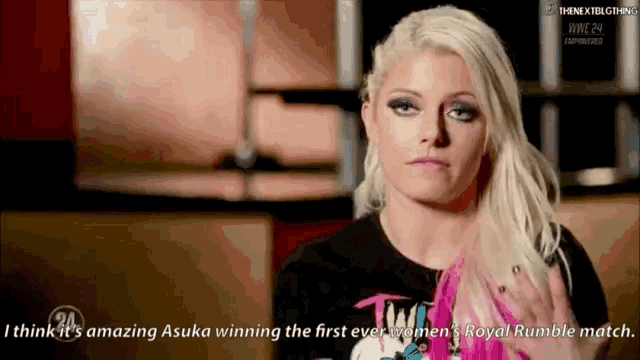 a woman with blonde hair and a black shirt is talking about winning the first ever women 's royal rumble match .