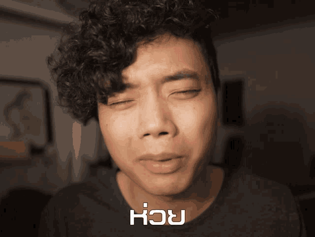 a man with curly hair is making a funny face with the word ach above his head