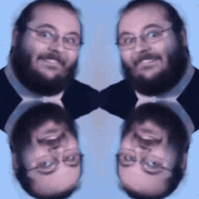 a man with a beard and glasses is standing in front of a blue background .