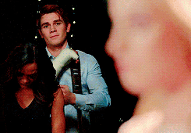 a man with a bandage on his arm is holding a woman 's arm