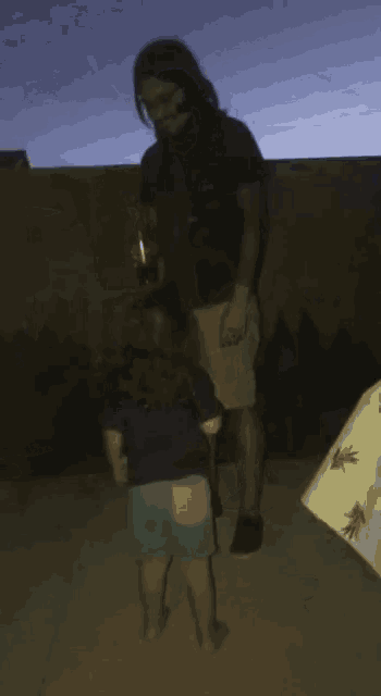 a man is holding a small child in his arms in a dark room