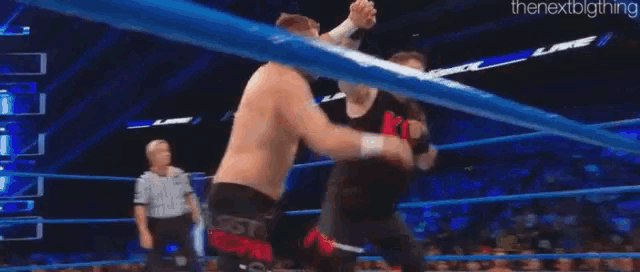 two men are wrestling in a ring and one of them is doing a flip .