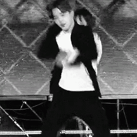 a man is dancing on a stage with a woman behind him .