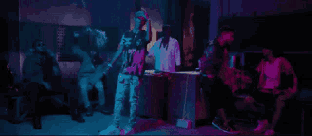 a group of people are gathered in a dark room with purple and blue lights