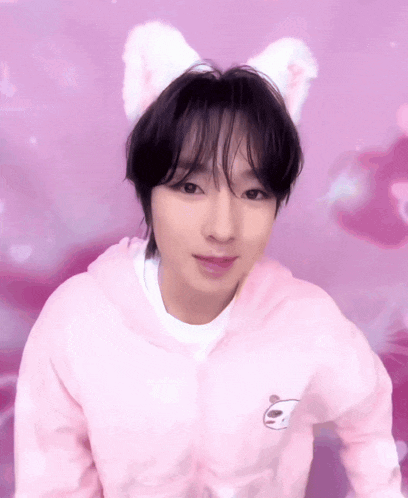 a young man wearing a pink hoodie with a panda on it