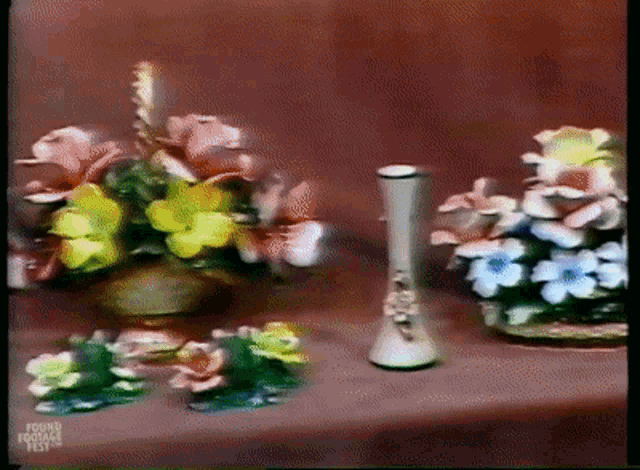 a vase of flowers sits on a table with the words funny footage fest written on the bottom