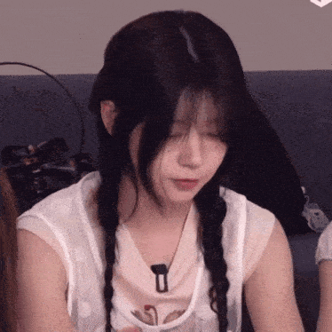 a girl with braids and a necklace with the letter t on it