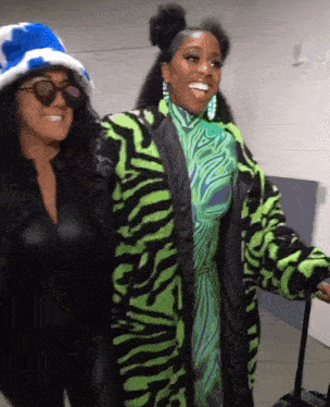 two women are standing next to each other and one is wearing a green zebra print coat
