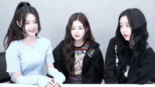 three girls are sitting next to each other with one wearing a sweatshirt that says ' nc ' on it