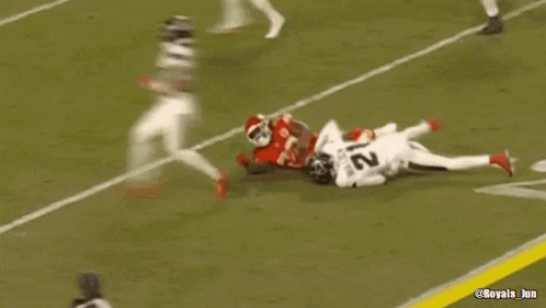 a football player is laying on the field after being tackled by another player during a game .