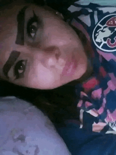 a woman laying on a bed wearing a shirt that says club america
