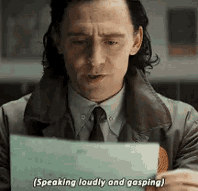 a man in a suit and tie is holding a piece of paper and says `` speaking loudly and gasping '' .