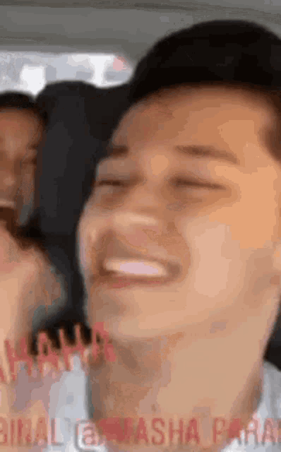 a close up of a man 's face with his eyes closed and a smile on his face .