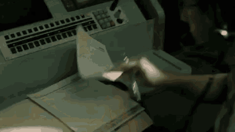 a person is holding a piece of paper in their hand in front of a machine .