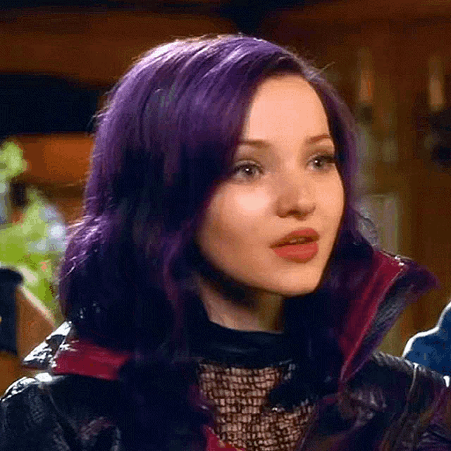 a woman with purple hair is wearing a black jacket and a black top .