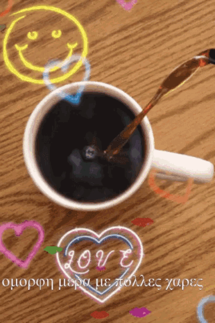 a cup of coffee with a smiley face and a heart with the word love written on it