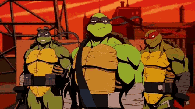 three teenage mutant ninja turtles are standing next to each other in front of a building .