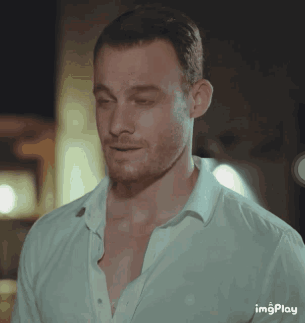 a man in a white shirt has a gif play icon on the bottom