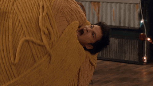 a man is wrapped in a yellow blanket and screaming
