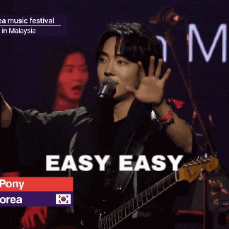 a man singing into a microphone while holding a guitar with easy easy written on the bottom