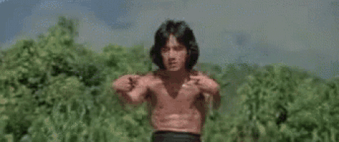 a man in a red shirt and white pants is standing in a field .