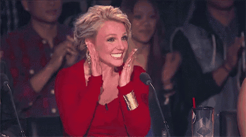 a woman in a red dress is sitting in front of a microphone with her mouth open .