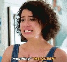 a woman with curly hair is crying and saying " mouthing yas queen " .