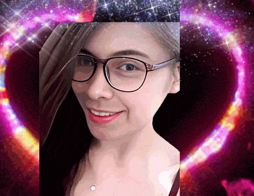 a woman wearing glasses is smiling in front of a heart