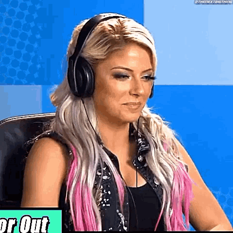 a woman wearing headphones is sitting in a chair and looking at the camera .