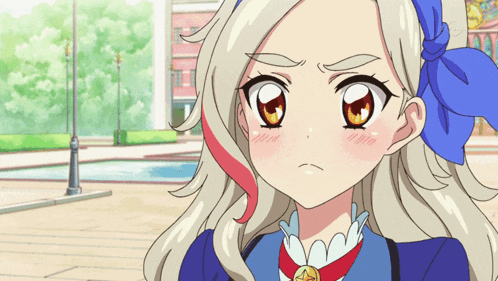a girl with blonde hair and a blue bow on her head looks angry