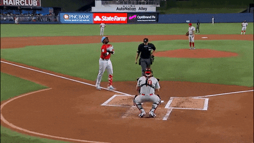a baseball game is being played on a field that has a hair club sign