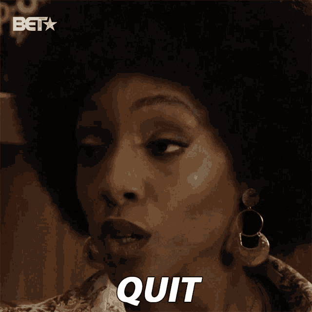 a close up of a woman 's face with the word quit written on her face