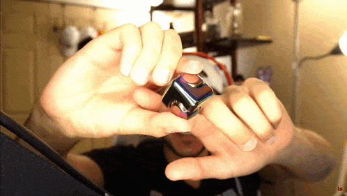 a person is holding a cube in their hands with the letter l on the bottom