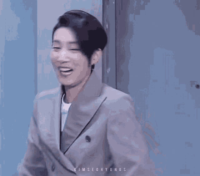 a man in a suit is laughing with the name kimseohyungs written on his chest