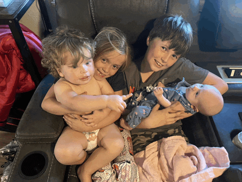 a boy holding a baby and a girl holding a baby