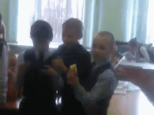 a blurry picture of a group of children standing around a table in a classroom