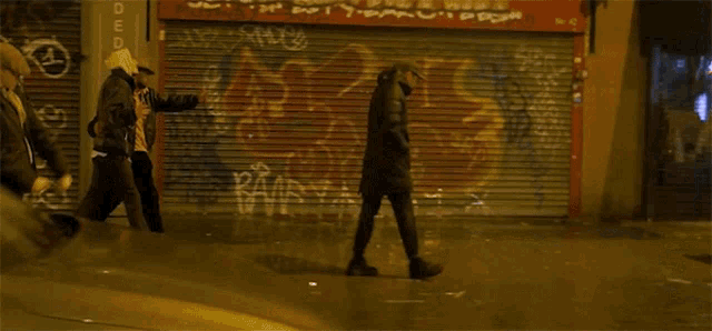 a person walking in front of a store that has graffiti on it and a sign that says off