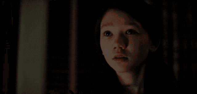 a person is on fire in a dark room with a door in the background