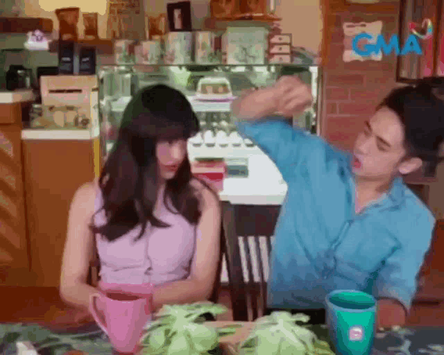 a man and a woman are sitting at a table .