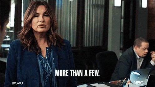 a woman says " more than a few " in front of a man in a suit
