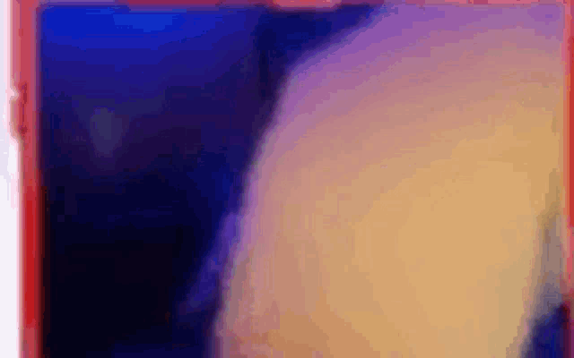 a close up of a red cell phone with a blurry picture of a person on the screen .