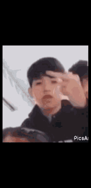 a blurry picture of a boy making a peace sign