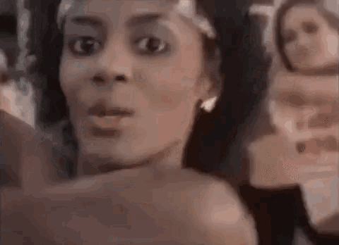 a woman is taking a selfie with a picture of herself in her hand .