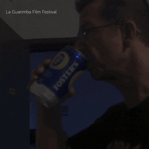 a person drinking from a can of fosters beer