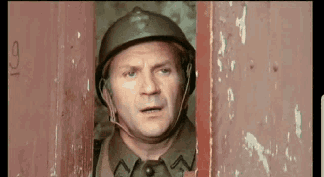 a man wearing a helmet is looking out of a doorway with the number 19 on it