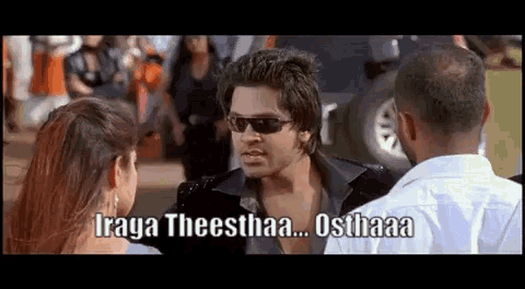 a man wearing sunglasses is talking to a woman in a movie .